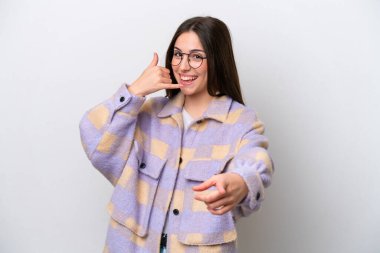 Beyaz arka planda izole edilmiş genç bir kız telefon hareketi yapıyor ve ön tarafı işaret ediyor.