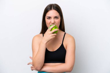 Young girl isolated on white background eating an apple