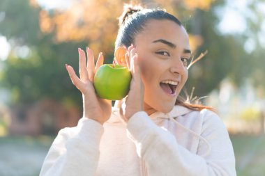 Elma tutan genç ve güzel bir bayan.