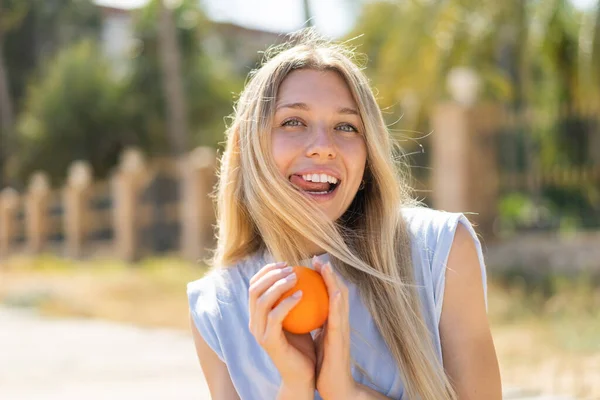 Молодая Блондинка Улице Держит Апельсин Счастливым Выражением Лица — стоковое фото