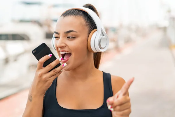 Молода Красива Жінка Відкритому Повітрі Слухає Музику Мобільним Телефоном Співає — стокове фото