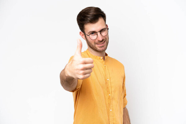 Young caucasian man isolated on white background with thumbs up because something good has happened