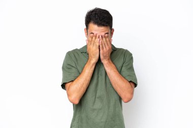 Genç yakışıklı, soyutlanmış beyaz bir arka plan, yorgun ve hasta bir yüz ifadesi var.