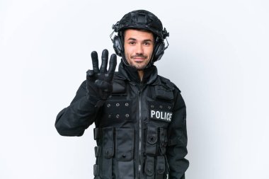 Beyaz arka planda izole edilmiş Kafkasyalı genç SWAT adamı mutlu ve parmaklarıyla üçe kadar sayıyor.