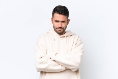 Beyaz arka planda izole edilmiş, mutsuz bir ifadeyle genç beyaz bir adam.