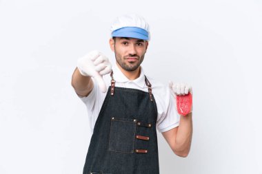 Kasap beyaz önlük giymiş ve izole edilmiş beyaz arka planda taze et servis ediyor.