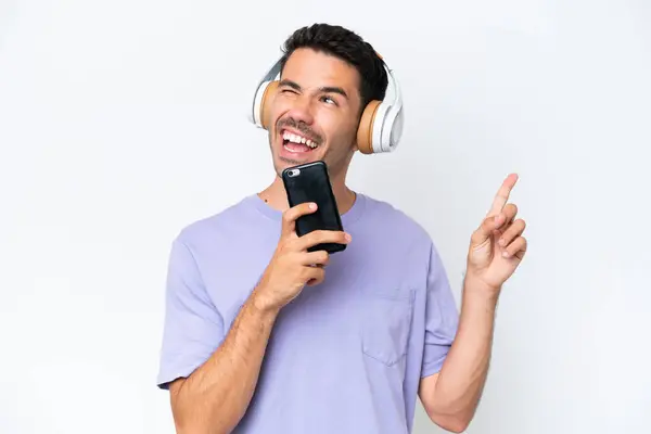 Mladý Pohledný Muž Přes Izolované Bílé Pozadí Poslech Hudby Mobilní — Stock fotografie