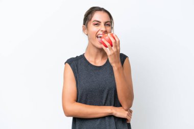 Genç, güzel Uruguaylı kadın beyaz arka planda izole edilmiş elma yiyor.