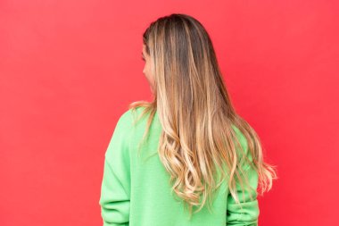 Genç Uruguaylı kadın kırmızı arka planda izole edilmiş.