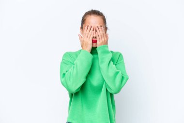 Beyaz arka planda izole edilmiş beyaz tenli genç bir kadın gözlerini elleriyle kapatıyor.