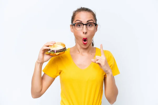 Young Caucasian Woman Holding Burger Isolated White Background Intending Realizes —  Fotos de Stock