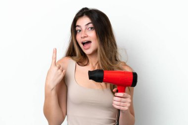 Beyaz arka planda izole edilmiş saç kurutma makinesini tutan beyaz saçlı genç bir kadın çözümü fark etmek için parmağını kaldırıyor.