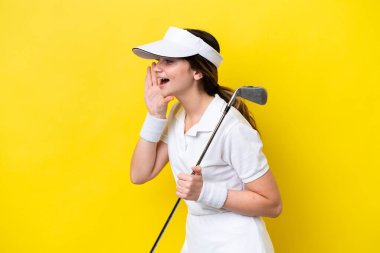 Sarı arka planda tek başına golf oynayan beyaz bir kadın ağzı açık bağırıyor.