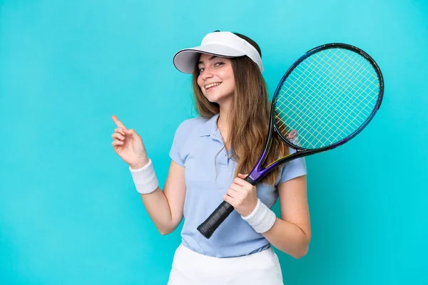 Jonge Tennisspeelster Vrouw Geïsoleerd Blauwe Achtergrond Wijzend Vinger Naar Zijkant — Stockfoto