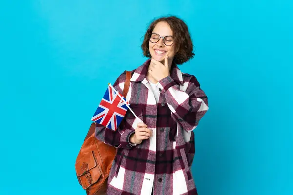 Młoda Angielka Trzymająca Flagę Zjednoczonego Królestwa Niebieskim Tle Patrząca Boku — Zdjęcie stockowe