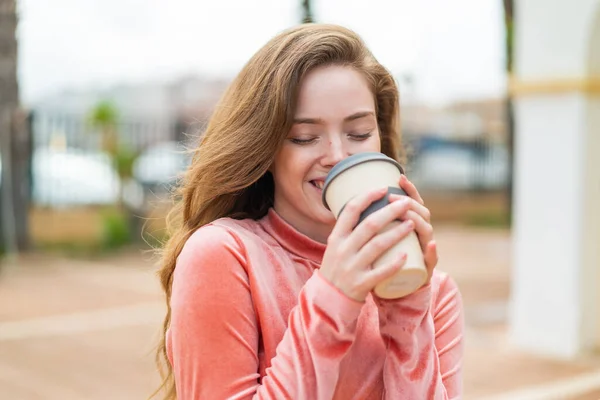 外面拿着咖啡的红头发年轻女人 — 图库照片
