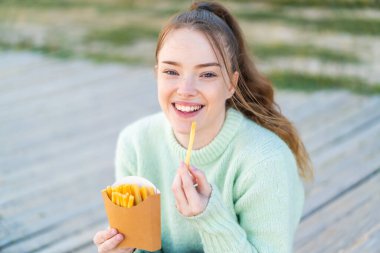 Genç ve güzel bir kız kızartma alıyor.