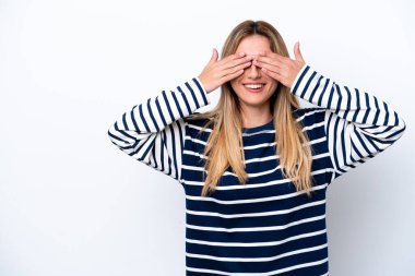 Young Uruguayan woman isolated on white background covering eyes by hands and smiling