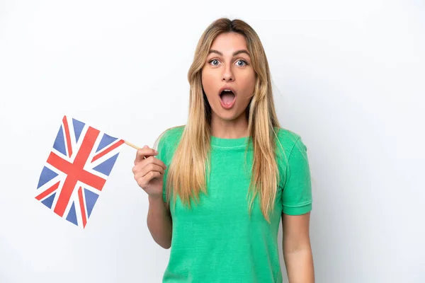 イギリスの国旗を持っている若いウルグアイの女性は 驚きとショックを受けた表情で白い背景に孤立しました — ストック写真
