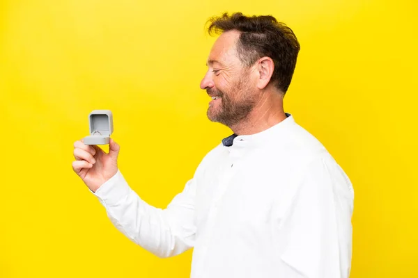 Middle Age Man Holding Engagement Ring Isolated Yellow Background Happy — Stok fotoğraf