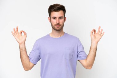 Beyaz arka planda Zen pozisyonunda beyaz tenli genç bir adam