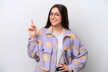 Beyaz arka planda izole edilmiş genç bir kız en iyinin işareti olarak parmağını kaldırıyor ve gösteriyor.