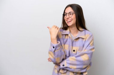 Young girl isolated on white background pointing to the side to present a product