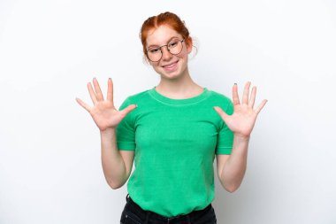 Beyaz arka planda izole edilmiş genç kızılımsı kadın parmaklarıyla ona kadar sayıyor.