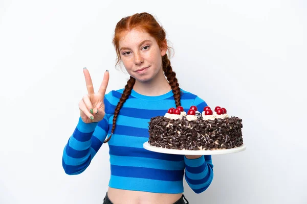 Młoda Rudawa Kobieta Trzyma Tort Urodzinowy Odizolowany Białym Tle Uśmiecha — Zdjęcie stockowe