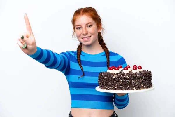 Młoda Rudawa Kobieta Trzyma Tort Urodzinowy Odizolowany Białym Tle Pokazując — Zdjęcie stockowe