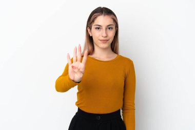 Beyaz arka planda izole edilmiş genç beyaz kadın mutlu ve parmaklarıyla dörde kadar sayıyor.