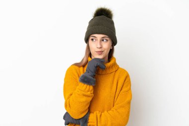 Kışlık şapkalı genç kız beyaz arka planda kuşkuları ve düşünceleri var.