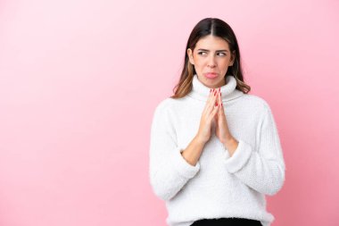 Pembe arka planda izole edilmiş genç bir İtalyan kadın bir şeyler planlıyor.