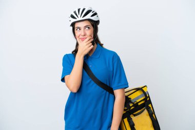 Young delivery woman with thermal backpack isolated on white background having doubts and with confuse face expression