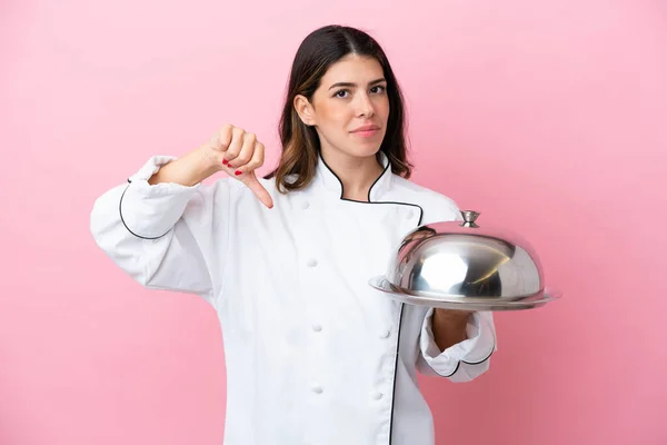 분홍색 배경에 뚜껑을 쟁반을 이탈리아의한 요리사는 부정적 표현으로 엄지손가락을 아래로 — 스톡 사진