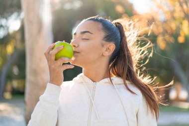 Elma tutan genç ve güzel bir bayan.