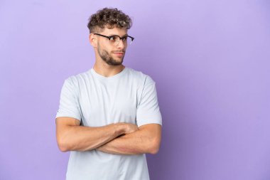 Mor arka planda izole edilmiş beyaz adam yan tarafa bakıyor.