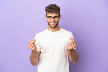 Mor arka planda izole edilmiş beyaz bir adam para hareketi yapıyor.