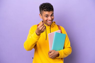 Mor arka planda izole genç Brezilyalı adam para hareketi yapıyor.