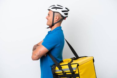 Beyaz arka planda, termal sırt çantalı beyaz tenli genç bir adam var.