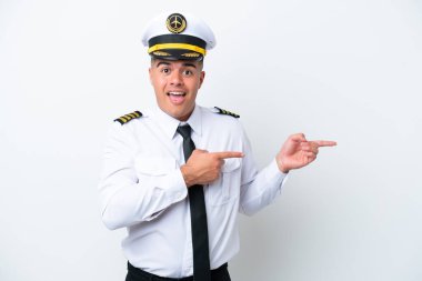Airplane pilot caucasian man isolated on white background surprised and pointing side