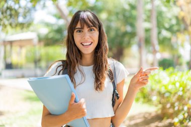 Dışarıdaki genç bayan şaşırdı ve parmağıyla işaret etti.