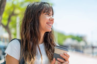 Açık havada genç bir kadın Neşeli bir ifadeyle
