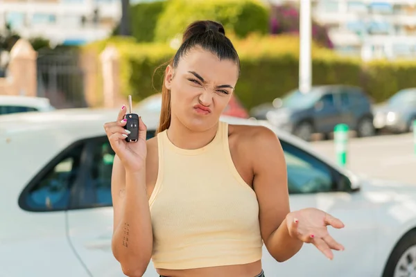 Junge Hübsche Frau Mit Autoschlüssel Freien Macht Zweifel Geste Während — Stockfoto