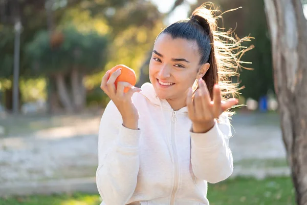 Joven Mujer Morena Bonita Sosteniendo Una Naranja Aire Libre Invitando — Foto de Stock