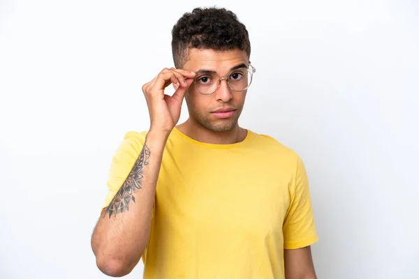 白を背景に孤立した若いブラジル人男性眼鏡と挫折感のある表情 — ストック写真