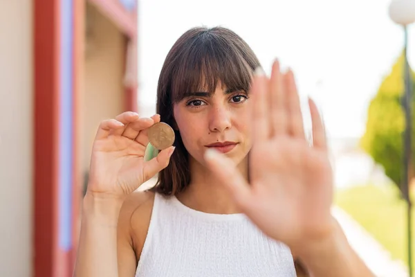 ビットコインを保持し 停止サインをする屋外の若い女性 — ストック写真