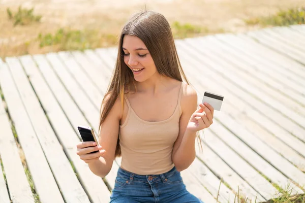 Nastolatka Zewnątrz Kupuje Pomocą Telefonu Komórkowego Kartą Kredytową — Zdjęcie stockowe