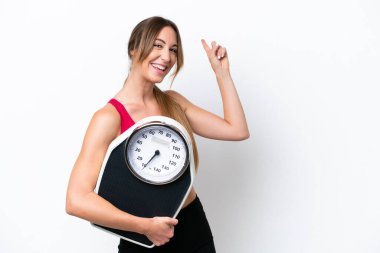 Beyaz arka planda tartı makinesiyle izole edilmiş beyaz bir beyaz kadın.