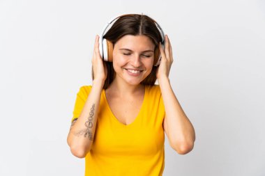 Genç Slovak kadın beyaz arka planda izole edilmiş müzik dinliyor.